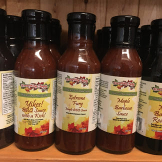 A lineup of five bottles of different flavours of maple barbecue sauce.