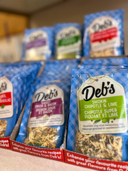 Photo of six varieties of Deb's Dips on display, including the Smokin' Chipotle and Lime, Sweet Onion and Bacon, Roasted Red Pepper, Spinach, and Roasted Garlic Lovers flavours.